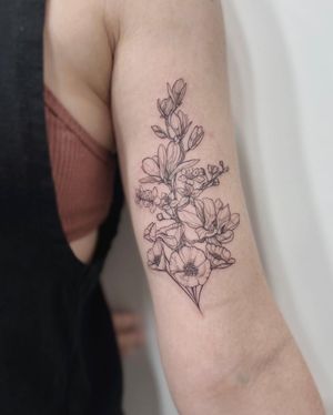 Get a stunning blackwork flower tattoo on your upper arm by the talented artist Polina. Embrace the beauty of nature with this intricate design.