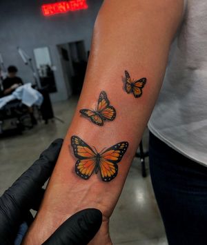 Artist Lim creates a stunning illustrative butterfly tattoo on the forearm, showcasing intricate details and vibrant colors.