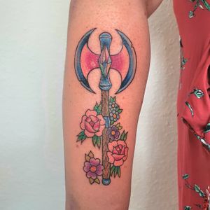 Colorful double axe tattoo in trans colors surrounded by flowers