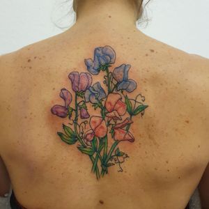 Colorful botanical snap pea tattoo between the shoulder blades