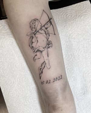 Elegant small lettering tattoo of an angel and cupid by tattoo artist Federico Colantoni, perfect for a forearm placement.