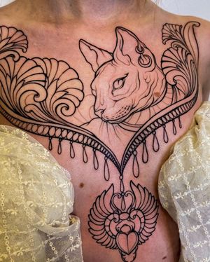 Elegant and intricate chest tattoo featuring a cat surrounded by delicate filigree details. Expertly done by Edyta.