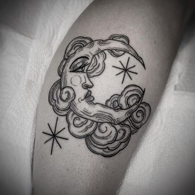 Elegant lower leg tattoo featuring a delicate fine line design of a moon and star, created by the talented artist Lamat