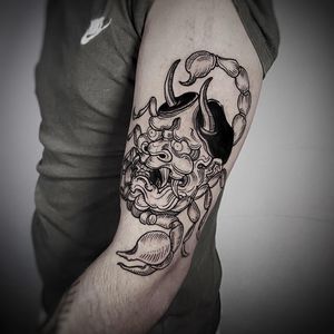Get inked with a stunning blackwork design by Lamat, featuring a fierce scorpion and haunting hannya mask on your upper arm.