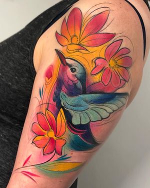 Adorn your upper arm with a stunning illustrative watercolor tattoo featuring a beautiful bird and flower design by Cloto.tattoos.