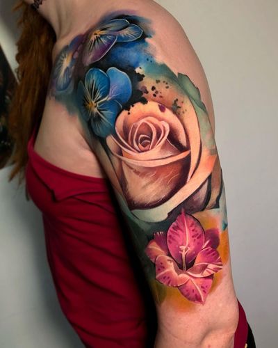 A beautiful illustrative floral design featuring watercolor elements, by Cloto.tattoos. Perfect for a sleeve tattoo.
