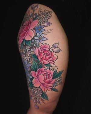 Beautiful watercolor flower tattoo on the upper leg, created by Aygul, featuring a vibrant and colorful floral design.