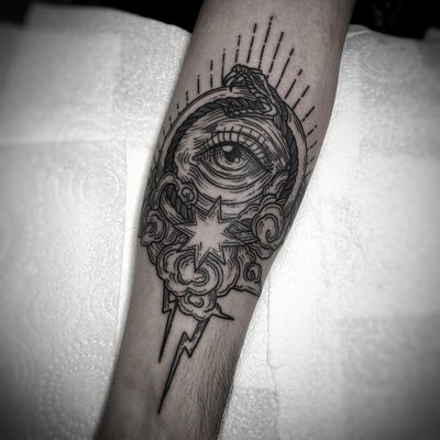 Black and gray fine line forearm tattoo featuring a mystical ouroboros snake with a mesmerizing eye by artist Lamat.