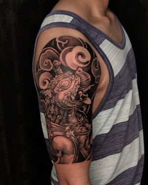 Get a unique and symbolic Japanese style tattoo on your upper arm, featuring clouds and a loyal dog, by talented artist Avi.