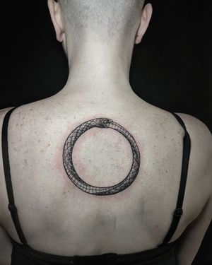 Elegantly intricate black and gray snake biting its own tail on the upper back, masterfully done by Luca Salzano.
