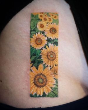 Beautiful watercolor sunflower framed tattoo on upper leg, done by talented artist Aygul.