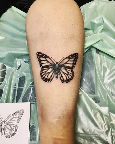 Elegant blackwork butterfly tattoo on upper arm by talented artist Frankie Brown. Embrace the beauty of transformation with this stunning design.