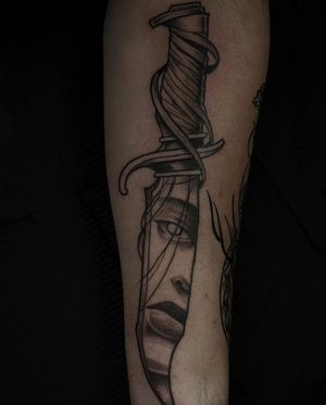 Eye-catching forearm tattoo featuring a knife and girl design, expertly done by Luca Salzano