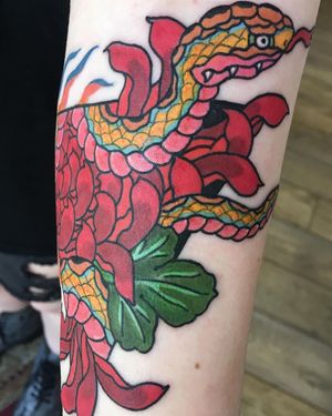 Get inked by Kiko Lopes with a stunning neo-traditional design featuring a snake and flower motif, perfect for your forearm.