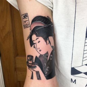 Capture the essence of a geisha with a cup of tea in this blackwork upper arm tattoo by Kiko Lopes.