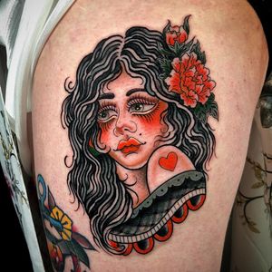 Vibrant new school design featuring a beautiful woman and colorful flowers, expertly done by tattoo artist Matthew Ono on the upper leg.