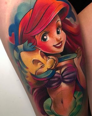 A stunning illustrative tattoo of a mermaid inspired by Ariel, featuring a beautiful girl with fish motifs, by Cloto.tattoos.