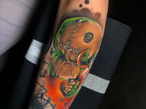 Get a whimsical and edgy anime voodoo doll tattoo on your forearm, featuring a lollipop, doll, and rope by Cloto.tattoos.
