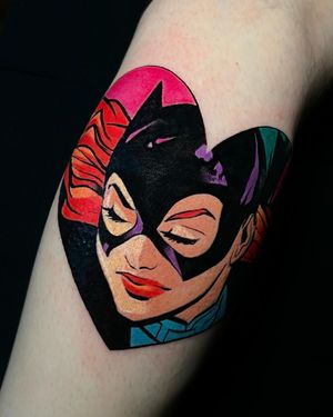 Unique upper arm tattoo featuring a blend of cat, heart, batman, and catwoman motifs in an anime illustrative style by Cloto.tattoos.