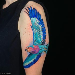 Get a stunning new school style bird tattoo on your upper arm with intricate details done by talented artist Marie Terry.