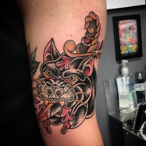 Enchant your upper arm with a fierce neo_traditional tattoo featuring a panther and dagger by Matthew Ono.
