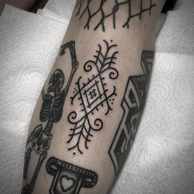 Intricate ornamental design by Lamat on the shin, blending fine line work with tribal motifs for a unique and captivating pattern tattoo.