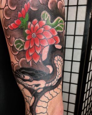 Experience the beauty of Japanese art with this illustrative tattoo by Kiko Lopes featuring a stunning snake and delicate flower design.