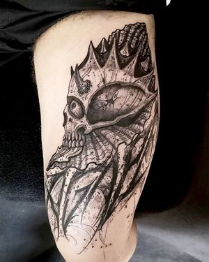 Fernando Joergensen's black and gray tattoo features a striking combination of a skull and shell on the upper leg. A bold and unique design for tattoo enthusiasts.