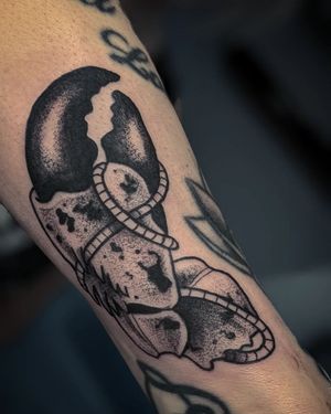 A stunning black and gray dotwork tattoo of a crab claw on the forearm, by the talented artist Luca Salzano.