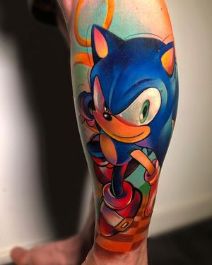 Get a vibrant anime tattoo of Sonic the Hedgehog with his iconic ring, inked by Cloto.tattoos for a playful and illustrative touch.