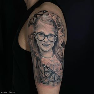 Marvel at Marie Terry's black and gray masterpiece on your upper arm. A stunning blend of realism and femininity.