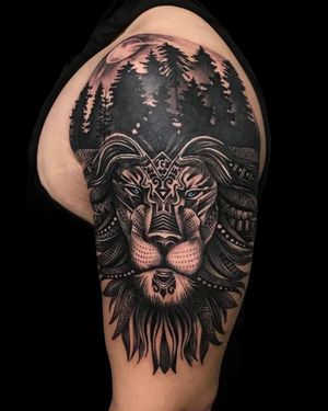 Avi's intricate design combines a majestic lion, a mystical tree, and intricate forest patterns on the upper arm.
