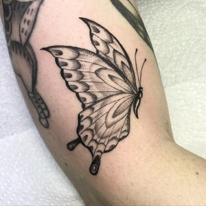 Elegant black and gray butterfly tattoo by Letitia Mortimer, perfect for your upper arm.