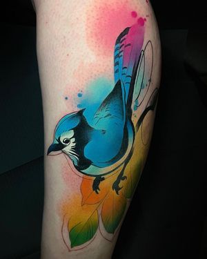 Get a stunning illustrative tattoo by Cloto.tattoos featuring a bird, tree, and leaf design on your lower leg. Stand out with this unique watercolor style!
