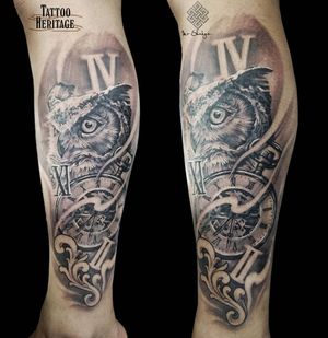 Marvel at this intricate black and gray piece featuring an owl perched on a clock surrounded by delicate filigree, expertly tattooed by Avi.