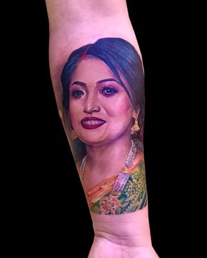 Capture the beauty and elegance of a woman with intricate earrings in this stunning forearm tattoo by Avi. Perfect blend of realism and illustration.