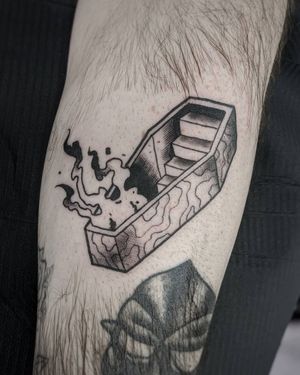 Experience the journey from coffin to fiery staircase in this stunning black and gray forearm piece by artist Luca Salzano.