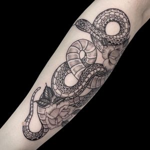 Capture the beauty of nature with this stunning black and gray traditional tattoo by Letitia Mortimer. The intricate design features a snake intertwined with a delicate flower.