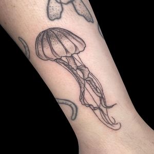Elegant black and gray jellyfish tattoo by Letitia Mortimer, perfect for your forearm. Capture the beauty of the deep sea with this stunning design.