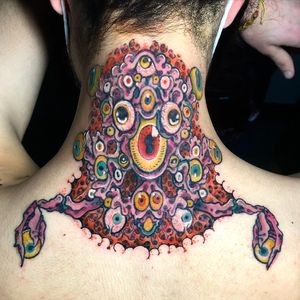 Experience a mesmerizing blend of new school and surrealism with this eye-catching upper back tattoo featuring a unique monster design by artist Matthew Ono.