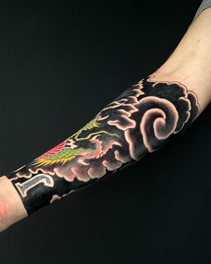Bold and dynamic japanese tattoo by Kiko Lopes featuring a fierce dragon surrounded by swirling clouds on the forearm.
