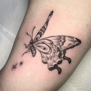 Elegant black and gray butterfly tattoo by Letitia Mortimer, delicately sketched with fine line work. Perfect for a subtle statement on the upper arm.