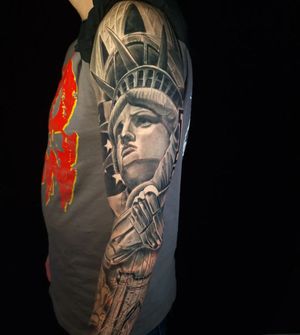 Impeccably detailed black and gray realism sleeve tattoo of a statue, created by Mauro Imperatori.