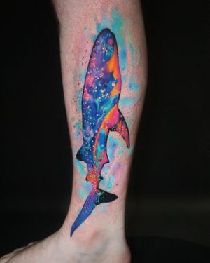 Dive into the cosmic depths with this stunning lower leg tattoo by Aygul, featuring a majestic whale swimming through a colorful galaxy.