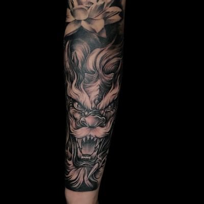 Avi's stunning black and gray illustrative piece combines a dog, dragon, and flower motif for a unique and mystical design on the forearm.