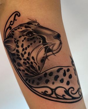 Unique black and gray neo traditional forearm tattoo featuring a leopard and the Leo zodiac symbol. Created by artist Edyta.