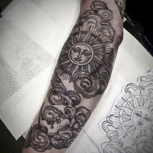 Stunning black and gray forearm tattoo by Lamat featuring intricate dotwork clouds, sun, and moon motifs for a mystical touch.