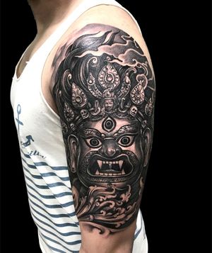 Beautiful Japanese tattoo featuring clouds, crown, mask, and filigree on the upper arm, created by Avi.