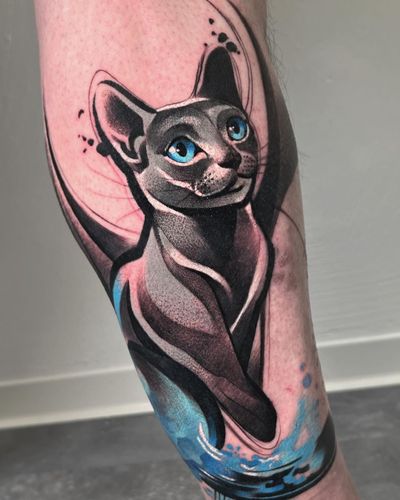Vibrant and detailed lower leg tattoo by Cloto.tattoos, featuring a realistic cat and intricate patterns in watercolor style.