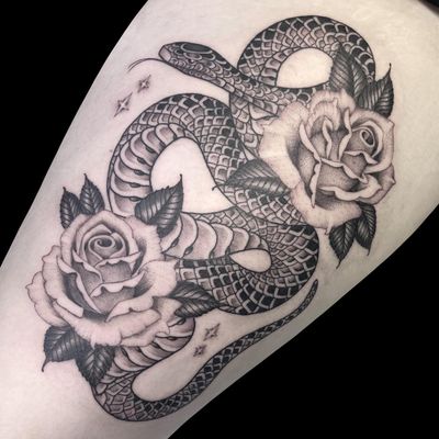 Beautiful black and gray tattoo by Letitia Mortimer featuring a fierce snake and delicate flower design on the forearm.